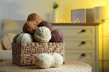 Canvas Print - Wicker basket with colorful yarns and knitting needles on coffee table in cozy room