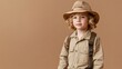 © Jittapon - Portrait of a curious and enthralled young child dressed in a safari inspired ensemble standing against a plain beige studio background with copy space for text  The image evokes a sense of wonder