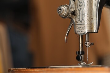 Sticker - Vintage sewing machine with thread on blurred background, macro view. Space for text