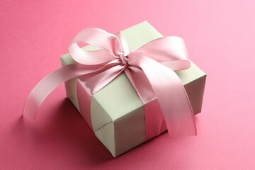 Wall Mural - Beautiful gift box with bow on pink background, closeup