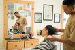 © Odua Images - A man is currently having his hair cut by a skilled barber in a cozy barber shop, surrounded by various hair styling tools and equipment