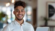 © Shutter2U - Smiling businessman holding a digital tablet in an office setting.