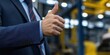 © gunzexx png and bg - A businessman in a suit confidently gives a thumbs-up, symbolizing high morale, approval, and success in a bustling corporate or industrial environment.
