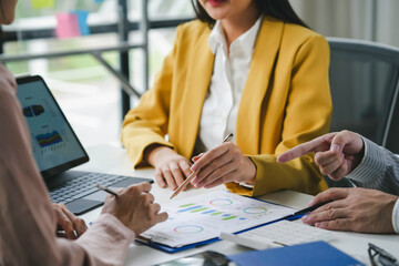 Businesspeople having a discussion about financial data while analyzing charts and graphs during a meeting