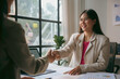© amnaj - Two businesswomen shaking hands after a successful business meeting in the office