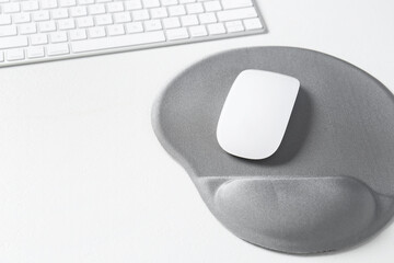 Sticker - Keyboard, mouse and mousepad with arm rest on white table, closeup. Space for text