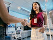 © Parichat - Two young businesswomen in a sleek office, shaking hands with confidence and happiness, symbolizing a successful partnership in a modern workplace