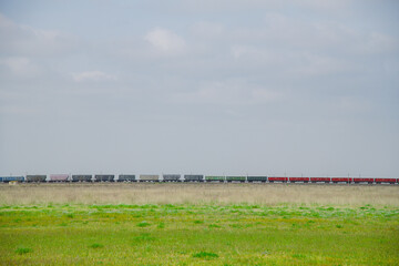 Wall Mural - Locomotive pulls a very large and heavy freight train with wagons and tank cars along a railway