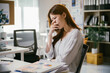 © PaeGAG - Young businesswoman is sitting at her desk with her hand over her mouth, feeling the stress of working with overwhelming paperwork