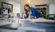 © PaeGAG - Young businesswoman is cheering with joy while looking at her laptop, happy about achieving a business goal or receiving good news