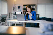 © PaeGAG - Businesswoman looking stressed while working late in the office. She is sitting at her desk with her head in her hands, looking at her laptop