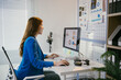 © PaeGAG - Businesswoman is working at her desk, analyzing financial data displayed on her computer screen.  She is smiling as she prepares for an upcoming presentation