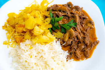 Traditional filet mignon stroganoff with mushrooms, French fries and rice