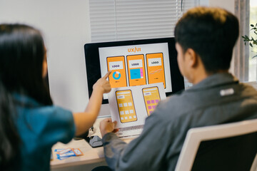 two young ui/ux designers are working together in the office, discussing over design prototypes on p