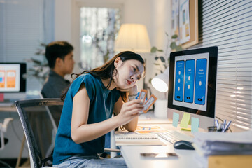 Stressed asian web designer faces creative block developing mobile app in office, struggling with ui/ux ideas, reflecting digital startup challenges