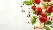 © loxia stock image - Closeup of cherry tomatoes, mozzarella balls, basil leaves, and peppercorns on a white background.