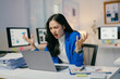 © PaeGAG - Stressed asian businesswoman at desk, yelling in frustration while working on laptop in busy office. Overworked and burnt out, balancing work and technology