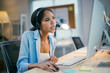© PaeGAG - Focused young businesswoman in office, dealing with a challenging situation on computer. Wearing headset, showing stress and concentration