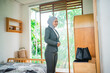© Odua Images - woman office worker in a hijab dresses up in front of the mirror in the bedroom