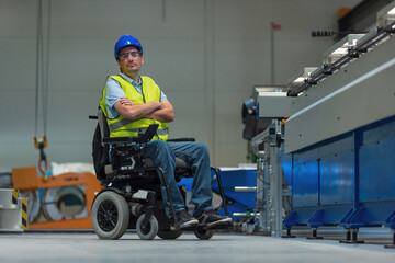 Man with disability in yellow vest, engineer in a factory unit checking a work process. inclusion and diversity concepts.