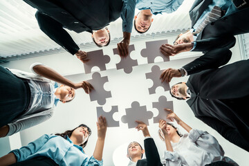multiethnic business people holding jigsaw pieces and merge them together as effective solution solv