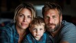 © JoxyAimages - A modern indoor portrait of a loving family comprising a father, mother, and their young child, all looking happily toward the camera in a cozy setting.