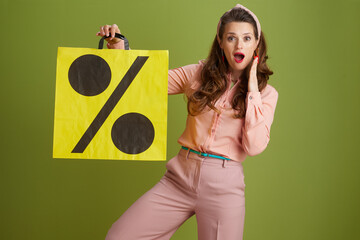 surprised healthy woman in pink blouse on green background