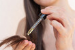 © Ольга Шефер - A young pretty woman applying natural oil to her hair against breakage and split ends