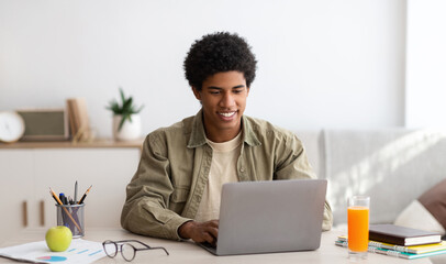 e-learning concept. african american teenager studying online on laptop computer at home. black yout