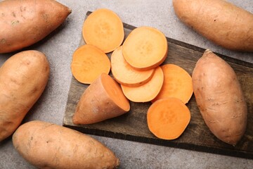 Sticker - Fresh raw sweet potatoes on gray textured table, top view