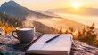 © Maria Mikhaylichenko - Steaming coffee cup and open notebook perched on rocky overlook, capturing breathtaking misty mountain sunrise view in golden morning light.
