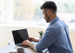 © Prostock-studio - Busy Male Entrepreneur Working On Laptop With Black Blank Screen In Office, Typing On Keyboard, Over Shoulder View, Mockup