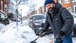 © Pinklife - The image captures a bearded man shoveling snow on a street lined with parked cars and brick buildings, emphasizing resilience and winter challenges in an urban environment.