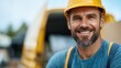 © Pinklife - A cheerful construction worker in a yellow hard hat smiles confidently at a building site, showing tools and construction equipment in the background beside a yellow van.