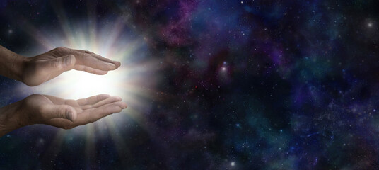 Wall Mural - Male Reiki Master sending cosmic  healing energy - male parallel hands with bright white light against a wide dark blue night sky deep space celestial background with copy space
