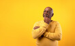 © Prostock-studio - Thoughtful senior African American man looking aside at empty space, touching his chin, deep in thought on orange studio background. Dreamy elderly black male offering place for your advertisement