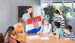 © JackF - Decent teacher showing Croatia flag to group of preteen schoolchildren in classroom during lesson