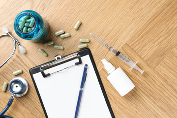 Wall Mural - Pharmacist. Many pills, stethoscope, syringe, clipboard and bottle of medical drops on wooden table, flat lay