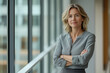© Alena - Mature businesswoman standing with confidence in a modern office