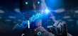 © Yingyaipumi - Robotic arm pointing at stock chart.Ai artificial intelligence tool analysis Data stock market.Investor use smart Ai robot automation technology for analysis graph data for decision trading,big data.