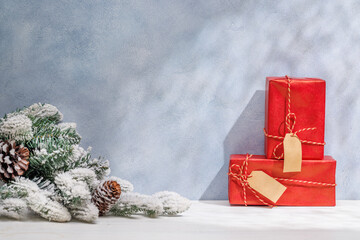 Aufkleber - Christmas template featuring gift boxes and snowy fir tree branches on a table with shadows and sun glares softly falling on the wall