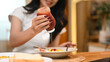 © Prathankarnpap - Cropped shot of young woman squeezing ketchup onto a breakfast dish consisting of toast