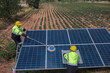 © VIEWFOTO STUDIO - Service worker in PPE. cleaning  with solar panel with wind turbine on background.