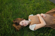 © Westend61 - Blond pregnant young woman lying on grass in meadow
