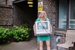 © Westend61 - Smiling blond woman recycling old television set