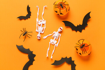 Wall Mural - Composition with skeletons, pumpkins, paper bats and spiders for Halloween celebration on orange background