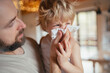 © Halfpoint - Sick boy with cold at home. Father helping little son to blow his nose.