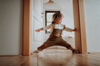 © Halfpoint - Portrait of an adorable little girl spreading her legs between door frame.