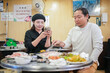 © Yoshida - A Korean man and a Japanese woman, both in their 30s and a married couple, are enjoying a meal of Samgyeopsal at a famous restaurant in Jung District, Seoul, Korea, on an autumn night in October.