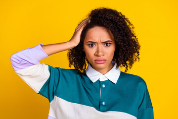 Sticker - Portrait of gloomy puzzled confused girl with wavy hairstyle wear teal shirt staring arm on head isolated on yellow color background